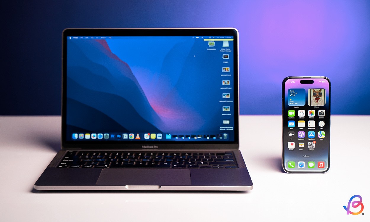MacBook và iPhone đặt cạnh nhau với màn hình sáng