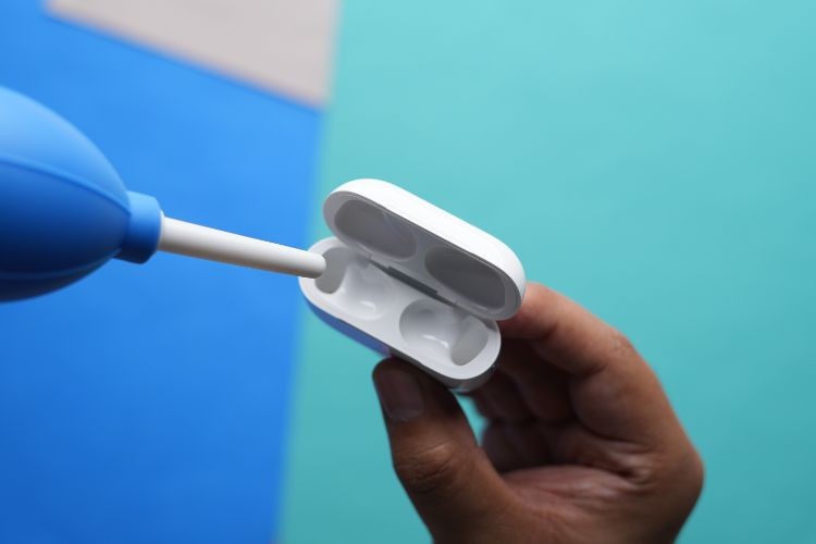Sử dụng ống thổi khí để làm sạch bên trong hộp sạc AirPods