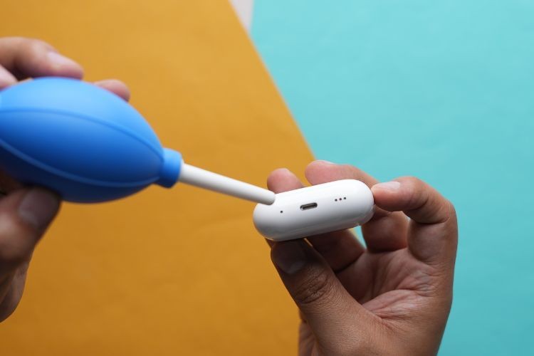 Sử dụng ống thổi khí để làm sạch cổng sạc AirPods